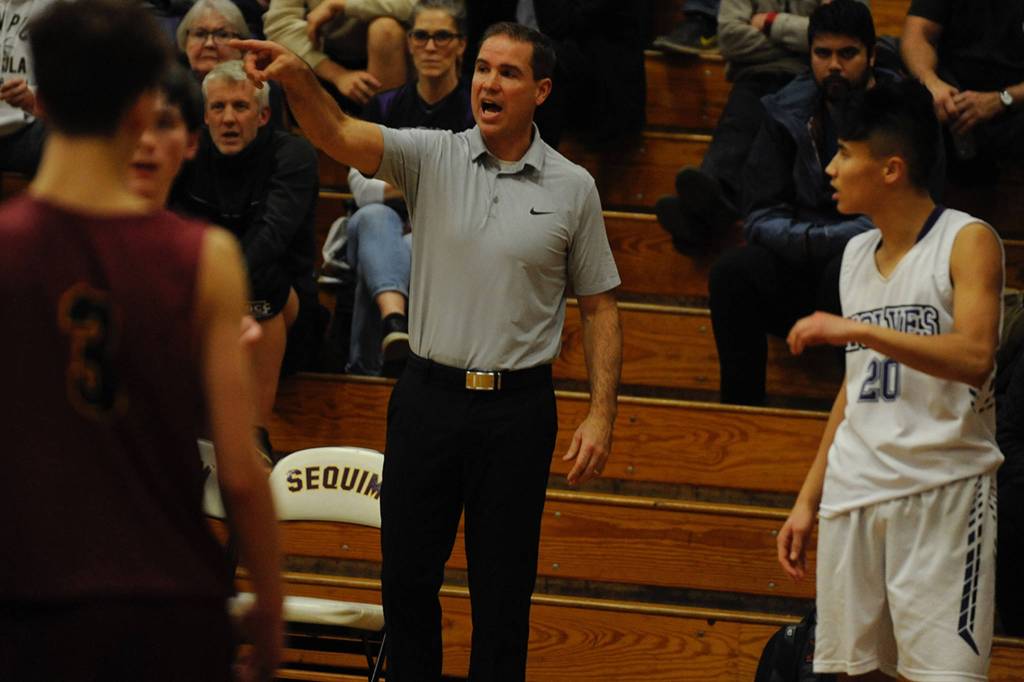 Sequim Wolves head coach Greg Glasser gives Riley Chen (20) and the rest of his team instructions in the closing minutes of the fourth quarter during the Wolves 49-48 win over the Kingston Buccaneers on Dec. 11. Sequim Gazette photo by Conor Dowley