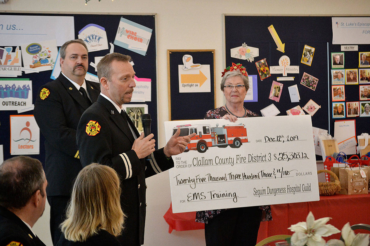 Using a donation from the Sequim-Dungeness Hospital Guild, Capt. Derrell Sharp with Clallam County Fire District 3 told a crowd of guild members on Dec. 12 in St. Lukes Episcopal Church that funds will support training for paramedics/EMTs and the public throughout 2020. Guild President Nancy McGovern and other board members presented the check to Sharp and Fire Chief Ben Andrews and other fire district leaders. Sequim Gazette photo by Matthew Nash