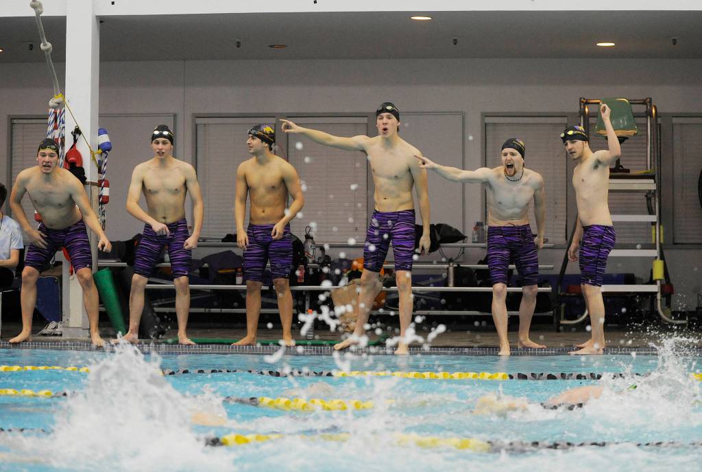 Sequim Highs swim team  from left Jordan Hurdlow, Rane Forcinel, Zen Graham, Will Plasch, Jesse Bobst and Myles Tadlock  cheer on Kaleb Needoba and teammates Deven Biehler and David Mecler in the 200 free in a Dec. 19 league meet against Port Angeles. Needoba broke the school record in the race. Sequim Gazette file photo by Michael Dashiell