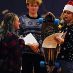 Gretta Thorson, right, presents an SHS student with a skateboard as part of the Sequim High School Winter Wishes assembly on Dec. 18. Sequim Gazette photo by Conor Dowley