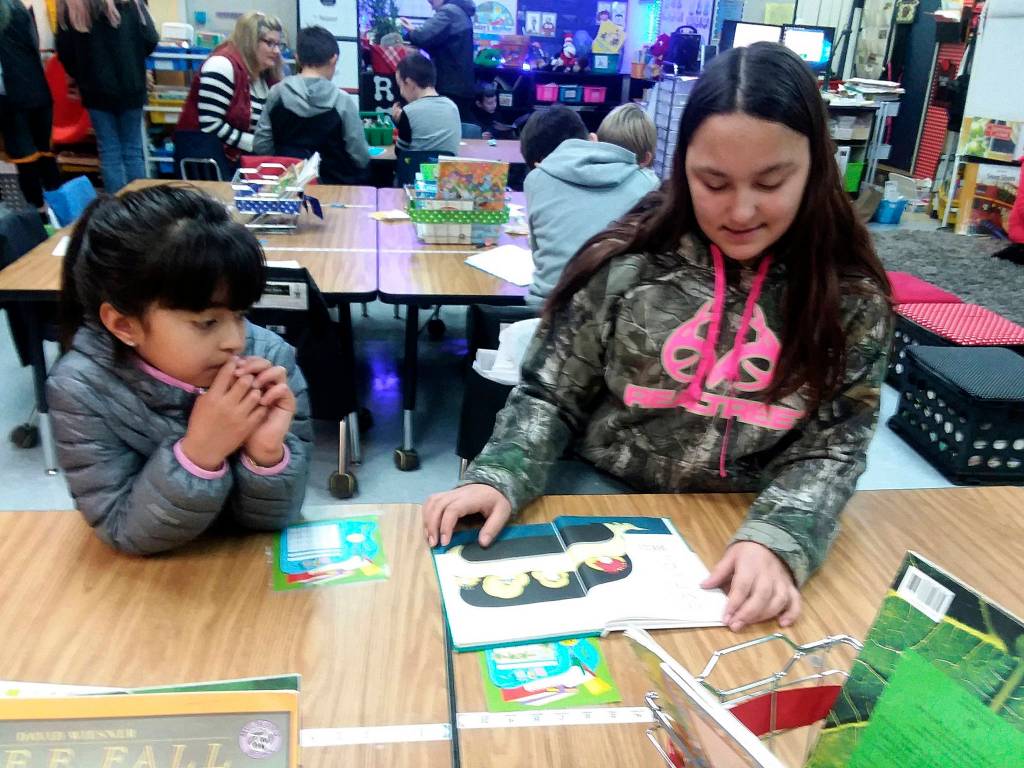 Fifth-grader Elizabeth Howard, right, reads with first-grader Camila Lopez. Photo by Patsene Dashiell