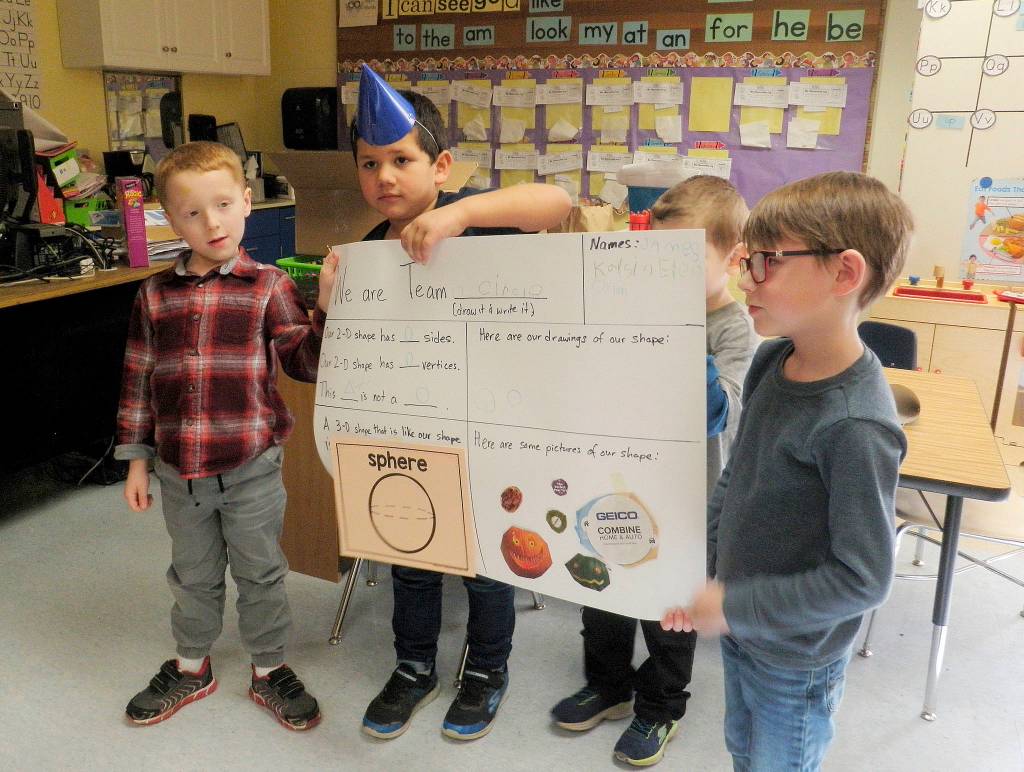 From left, Dylan Purkey, Eden Torres Ayala, Kaysin Gluth (behind presentation board) and James Keehn from Team Circle informed classmates that circles have zero sides and zero vertices.