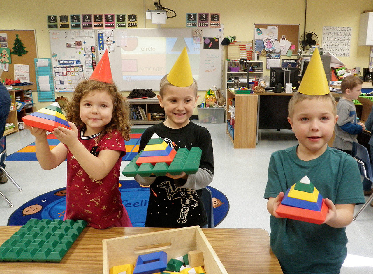 Kindergarteners (from left) Amelia Moose, Atticus Reed and Wesley Priest use interlocking blocks to create 3-D triangles during a shape fair in Lorrie Corders classroom at Helen Haller Elementary School.