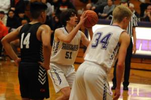 Above: Sequim Wolves freshman forward Cole Smithson takes a free throw in the 
4th quarter of the Wolves 57-55 win over the Central Kitsap Cougars on Jan. 3. Smithson only scored two points on the night, but they came in the form of two crucial free throws in the last minute to help secure the win. Below: Sequim Wolves freshman forward Isaiah Moore tries to block a shot from Central Kitsap Cougars forward Ethan Searer in the third quarter Sequim Gazette photos by Conor Dowley