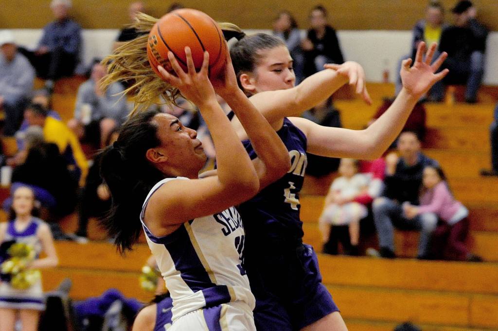 Sequim Wolves guard Hannah Bates (right) drives inside against North Kitsap Vikings guard Kamora McMillian during the second quarter of the Wolves 78-49 win over the Vikings on Jan. 31. Bates scored 16 points off the bench, and Wolves head coach Linsay Rapelje remarked after the game she was playing so well it was hard to take her off the court. Sequim Gazette photo by Conor Dowley                                Sequim Wolves post Jayla Julmist (left) goes up for a contested shot against North Kitsap Vikings guard Sophia Baugh in the first quarter of the Wolves 78-49 win over the North Kitsap Vikings on Jan. 31. Sequim Gazette photo by Conor Dowley