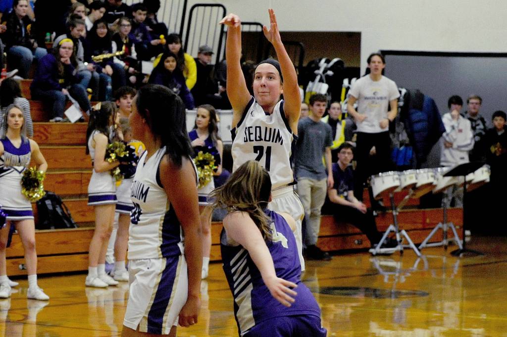 Sequim Wolves guard Hannah Bates (right) drives inside against North Kitsap Vikings guard Kamora McMillian during the second quarter of the Wolves 78-49 win over the Vikings on Jan. 31. Bates scored 16 points off the bench, and Wolves head coach Linsay Rapelje remarked after the game she was playing so well it was hard to take her off the court. Sequim Gazette photo by Conor Dowley                                Sequim Wolves guard Kalli Wiker (21) takes a 3-point shot in the fourth quarter of the Wolves 78-49 win over the North Kitsap Vikings on Jan. 31. Wiker tied the overall Sequim High School record (set by Art Green in 1991) for 3-pointers made in a single game with eight for the second time this season, and lead the team with 27 points on the night. Sequim Gazette photo by Conor Dowley