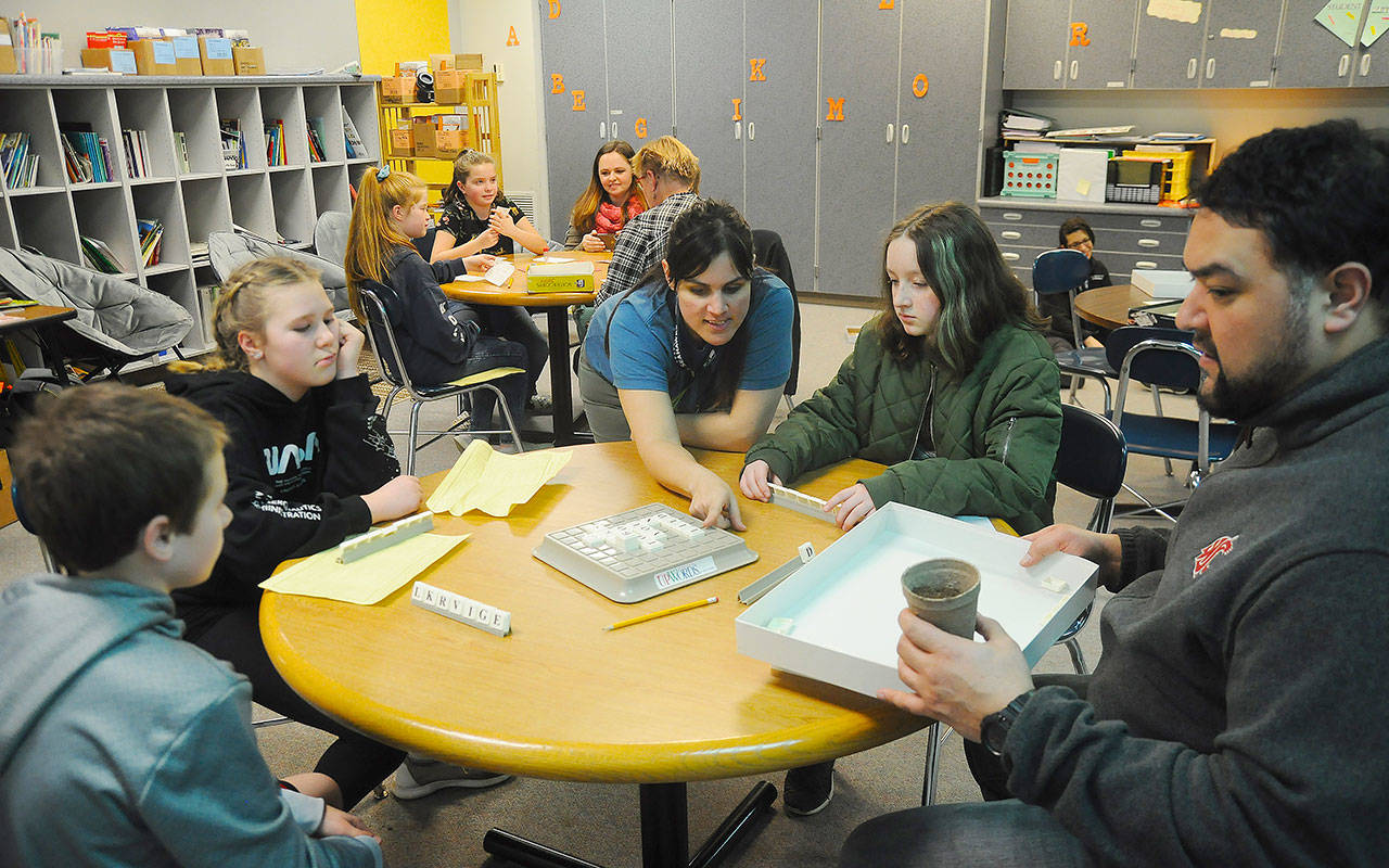 First-grade teacher Melissa Withrow, center, helps students and parents play a game of Upwords during Family Reading Night on Jan. 29. Sequim Gazette photos by Michael Dashiell