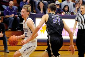 Sequim Wolves forward Stewart Duncan (33) looks for space around the perimeter while North Kitsap Vikings forward Logan Chmielewski closes in during the second quarter of the Vikings 83-42 win over the Wolves on Jan. 31. Duncan, one of two Wolves players honored for senior night before the game, hit a trio of 3-pointers in the first half and 11 points overall on the night. Sequim Gazette photo by Conor Dowley