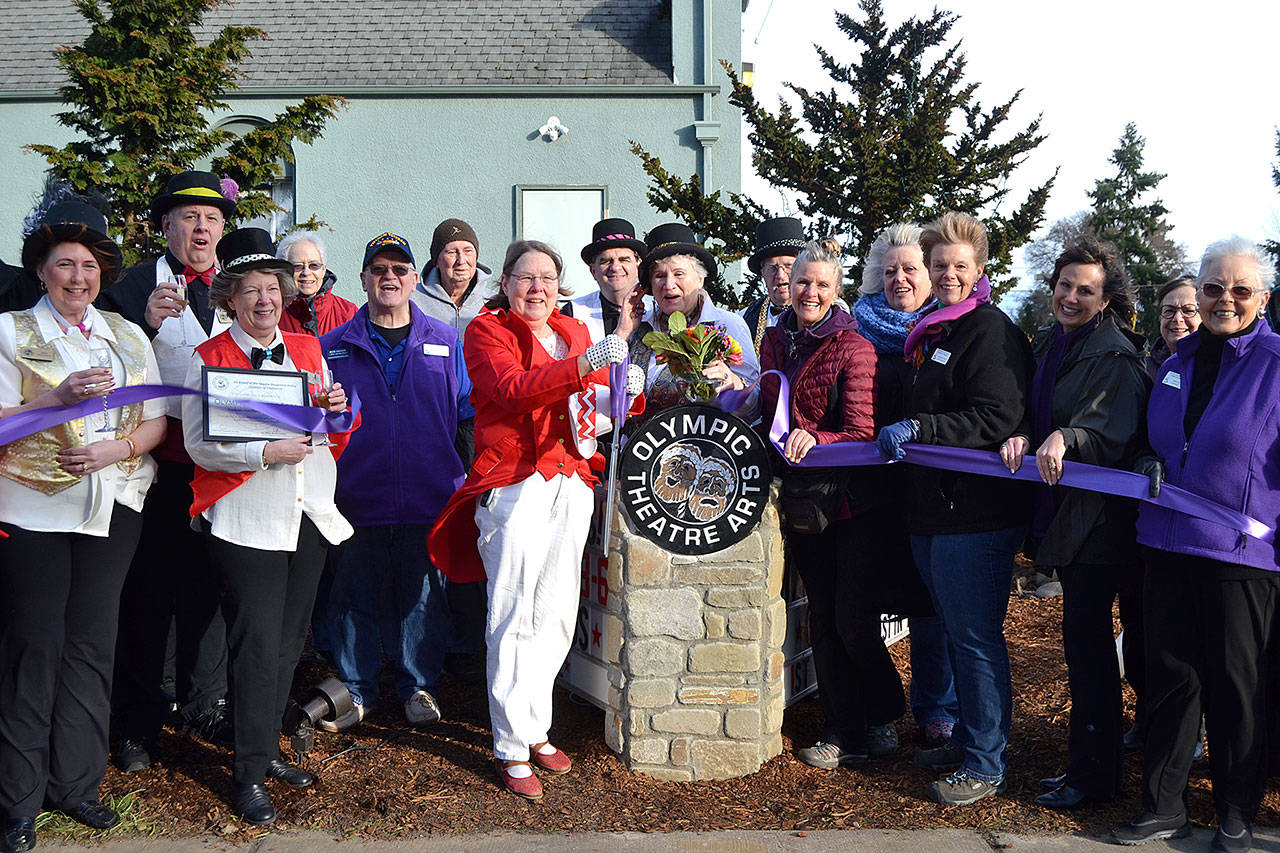 Executive Director Carol Willis cuts the ribbon for Olympic Theatre Arts new sign on Feb. 1 as part of an open house with theatre supporters and members of the Sequim-Dungeness Valley Chamber of Commerce. Sequim Gazette photo by Matthew Nash