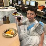 A toga-attired Blake Lawless raises a glass of fruit juice to symbolize a toast during ancient Roman times. A common Roman meal in ancient times included fish, cheese, bread and grapes. Photo by Robin Forrest