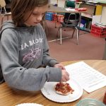 Kaylee Meyer follows the recipe she created for a mini pizza as part of a writing project. Photo by Melissa Sagara