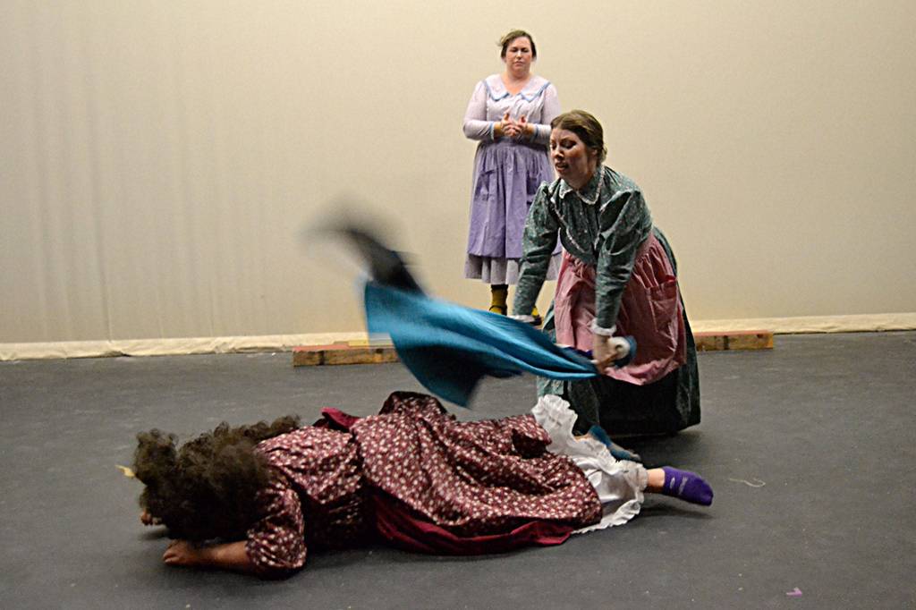 Charisa Silliman puts out flames from a fire on Maddie Montana as SaraJane Benjamin looks on. Actresses say Quilters shows the many ups and downs of pioneer womens lives traveling west. Sequim Gazette photo by Matthew Nash
