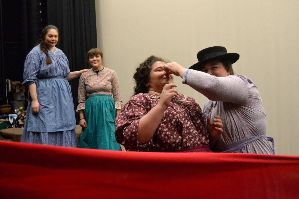 Actresses with Quilters ready quilts while singing Needles Eye to celebrate a mans 21st birthday on the frontier. Some of the women are family members while others are hoping to catch his eye, says director Richard Stephens. Right, SaraJane Benjamin looks to baptize Maddie Montana during a scene. Sequim Gazette photos by Matthew Nash