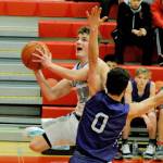 Olympic Trojans guard Tyler Lindal (left) jumps past Sequim Wolves guard Dallin Despain (0) in the second quarter of the Trojans 59-47 win over the Wolves in an Olympic League tiebreaker game on Feb. 8 that sent the Trojans to the district playoffs. Sequim Gazette photo by Conor Dowley