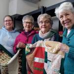 Showing a completed childs quilt and an unfinished quilt top are, from left Alane Olson, Jane Olson, Ruthie Armstrong and Jean Cameron, four of the women who have made more than 5,000 quilts at Dungeness Valley Lutheran Church in the past quarter-century. Submitted photo