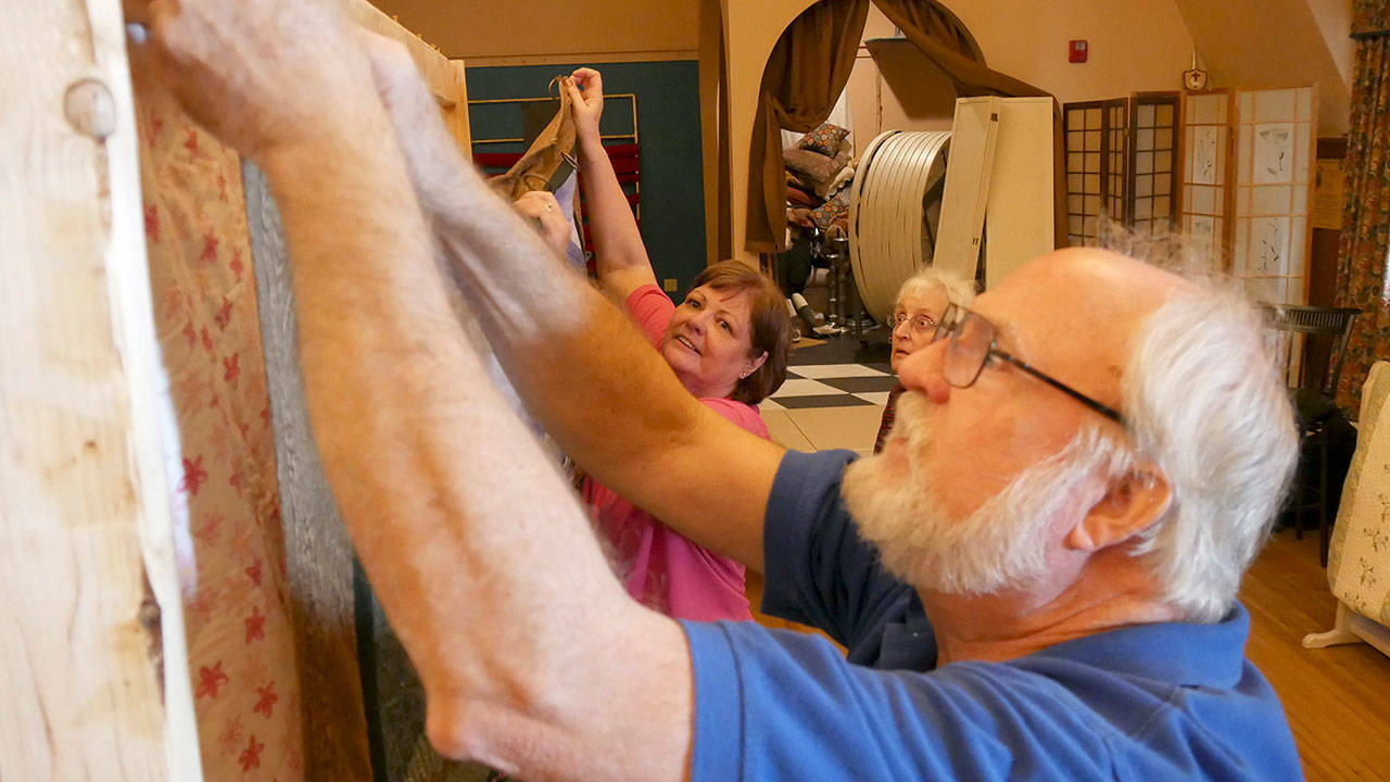 Ed and Linda Alders hang a quilt as AnnaLee Smith looks on. Photos courtesy of Olympic Theatre Arts