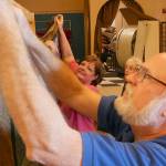 Ed and Linda Alders hang a quilt as AnnaLee Smith looks on. Photos courtesy of Olympic Theatre Arts