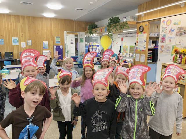 Left, students in Greywolf Elementary School teacher Carla Dreschers kindergarten class enjoy some Cat in the Hat-themed activities on March 2. Right, high schooler Rafael Flores listens in to first grader Nevaeh Norlin read a Dr. Seuss book in Pattie Hagans class. Submitted photos