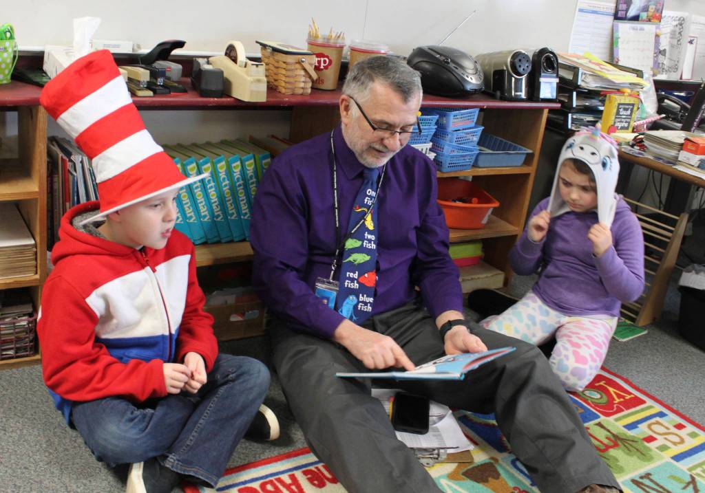 Sequim Middle School teacher Mr. Miko reads to first-graders Derrick Brawner and Hailey Groomes on March 2. Submitted photo