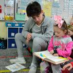 High schooler Rafael Flores listens in to first grader Nevaeh Norlin read a Dr. Seuss book in Pattie Hagans class. Sequim Gazette photo by Matthew Nash