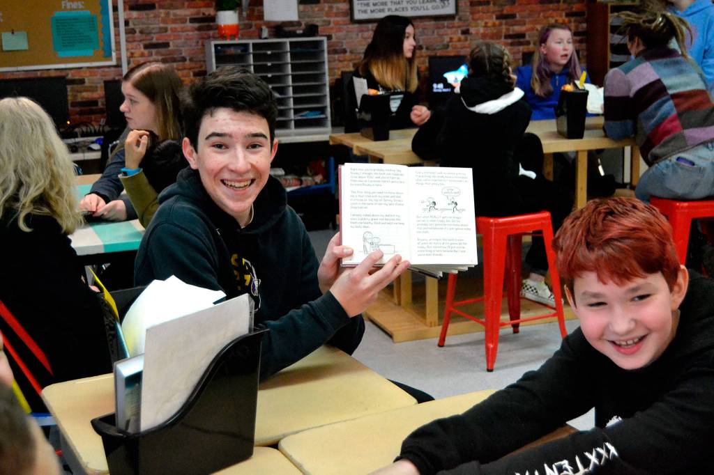 Dustan Koch holds up a copy of Diary of a Wimpy Kid after a funny moment he read aloud to Gage Reynolds and other students in Meredith Vincents fifth grade homeroom on Monday. Sequim Gazette photo by Matthew Nash