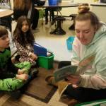 Sequim High School student Morgan Tate reads with Helen Haller Elementary School second-graders Harley Bullington, left, and Edyn Samudio in Renee Mullikins classroom. Tate is a former student of Mullikins. Haller students dressed in pajamas for Pajama Monday. Photo by Patsene Dashiell