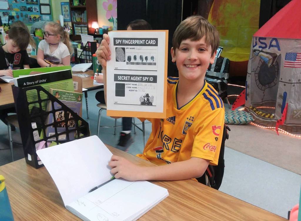 Third-grader Ryder McCreary from Emily Ellefsons classroom at Helen haller Elementary School fills in new answers to clues in his Spy Folder. Every day students earn clues to help them solve the case of the alien (extraterrestrial) who is trying to take over the International Space Station. Photo by Patsene Dashiell