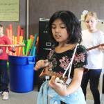 From left, Greywolf third-graders Alice Hodge, Annalee Rodriguez and Madelyn Schroeder work on their strumming technique in a recent music lesson. Submitted photo