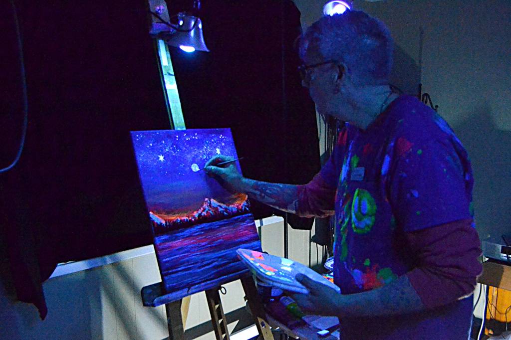Artist Craig Robinson paints with UV paints during the Interactive Light Experience curated by artist Ross Brown in Pioneer Memorial Parks clubhouse. Sequim Gazette photo by Matthew Nash