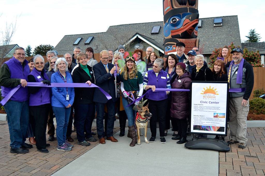 Sequim Mayor William Armacost cuts the ribbon for the Sequim Sunshine Festival on Friday afternoon to usher in the event on March 6-7. Sequim Gazette photo by Matthew Nash