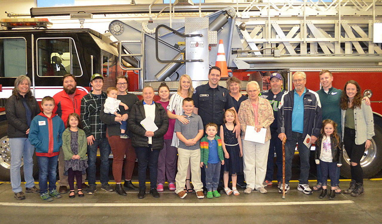 Casey Sires, center, is joined by friends and family at a Clallam County Fire District 3 badge pinning ceremony on March 12. Photo courtesy of Clallam County Fire District 3