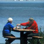 With the New Dungeness Lighthouse near the end of Dungeness Spit in the distance, Jennifer and Ron Parmenter of Sequim take advantage of a warm and sunny day with a picnic at Dungeness Landing County Park north of Sequim in June 2019. New Dungeness Light Station buildings are closed to the public throughout the duration of the COVID-19 coronavirus issue. File photo by Keith Thorpe/Olympic Peninsula News Group