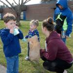 Hayden Helfer, 4, left, opens a milk carton as his sister, Ashlyn Helfer, 2, brother, Azriel Castillo, 11, and mother, Kristen Rutherford of Port Angeles, visit Hamilton School in Port Angeles for free meal for children on March 17. Photo by Keith Thorpe/Olympic Peninsula News Group