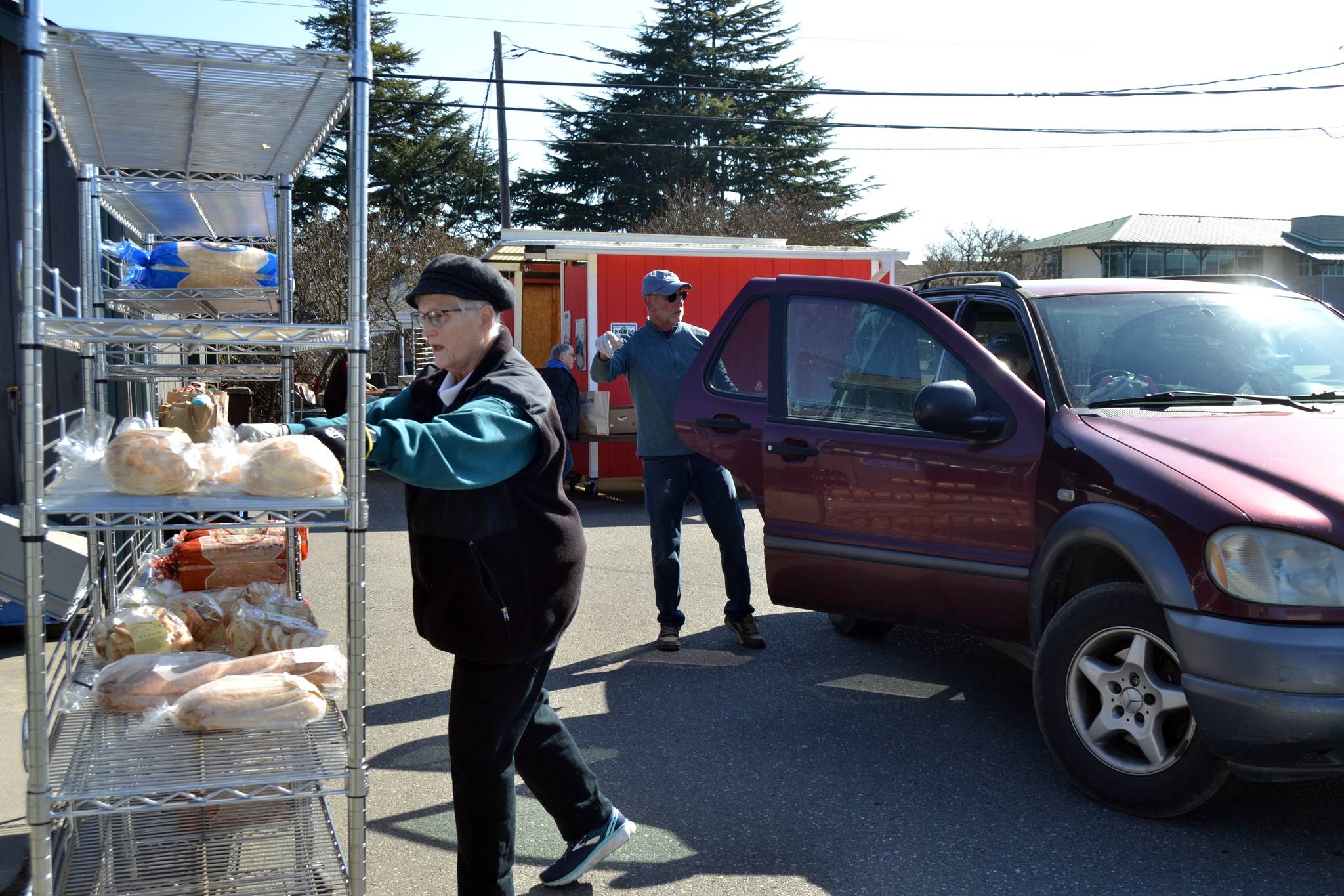 Janice Orth gathers some bread for a visitor of the Sequim Food Bank as fellow volunteer Steve Allen helps her load items in the back of the vehicle on March 20. Sequim Gazette photo by Matthew Nash