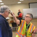 Linda Johannessen, Community Emergency Response Team No. 9 member, checks the temperature of firefighter/EMT Jeff Nicholas before he enters the Emergency Coordinating Center in the Guy Cole Event Center on March 23. Sequims response to COVID-19 will work out of the facility for the immediate future. Sequim Gazette photo by Matthew Nash