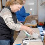Volunteers Donna Fraser of Port Angeles, front, and Lori Shafer of Joyce fashion homemade face shields to be used by first responders when interacting with potential COVID-19 patients. The pair were working last week in the countys emergency management vehicle outside the Clallam County Courthouse in Port Angeles. Photo by Keith Thorpe/Olympic Peninsula News Group