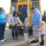 Helping hand out meals to Sequim youths on March 26 are, from left, bus driver Vienna Barron, teacher Gwen Rudzinski and Shirley Sheppard of Sodexo. The Sequim School District is distributing breakfast and lunch meals throughout the area each weekday. With parents Tony and Leslie Endicott (not pictured) looking on, Hadley, 4, Gracie, 3, and Logan, 14, receive their meals. Sequim Gazette photo by Michael Dashiell