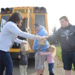 Helping hand out meals to Sequim youths on March 26 are, from left, bus driver Vienna Barron, teacher Gwen Rudzinski and Shirley Sheppard of Sodexo. The Sequim School District is distributing breakfast and lunch meals throughout the area each weekday. With parents Tony and Leslie Endicott (not pictured) looking on, Hadley, 4, Gracie, 3, and Logan, 14, receive their meals. Sequim Gazette photo by Michael Dashiell