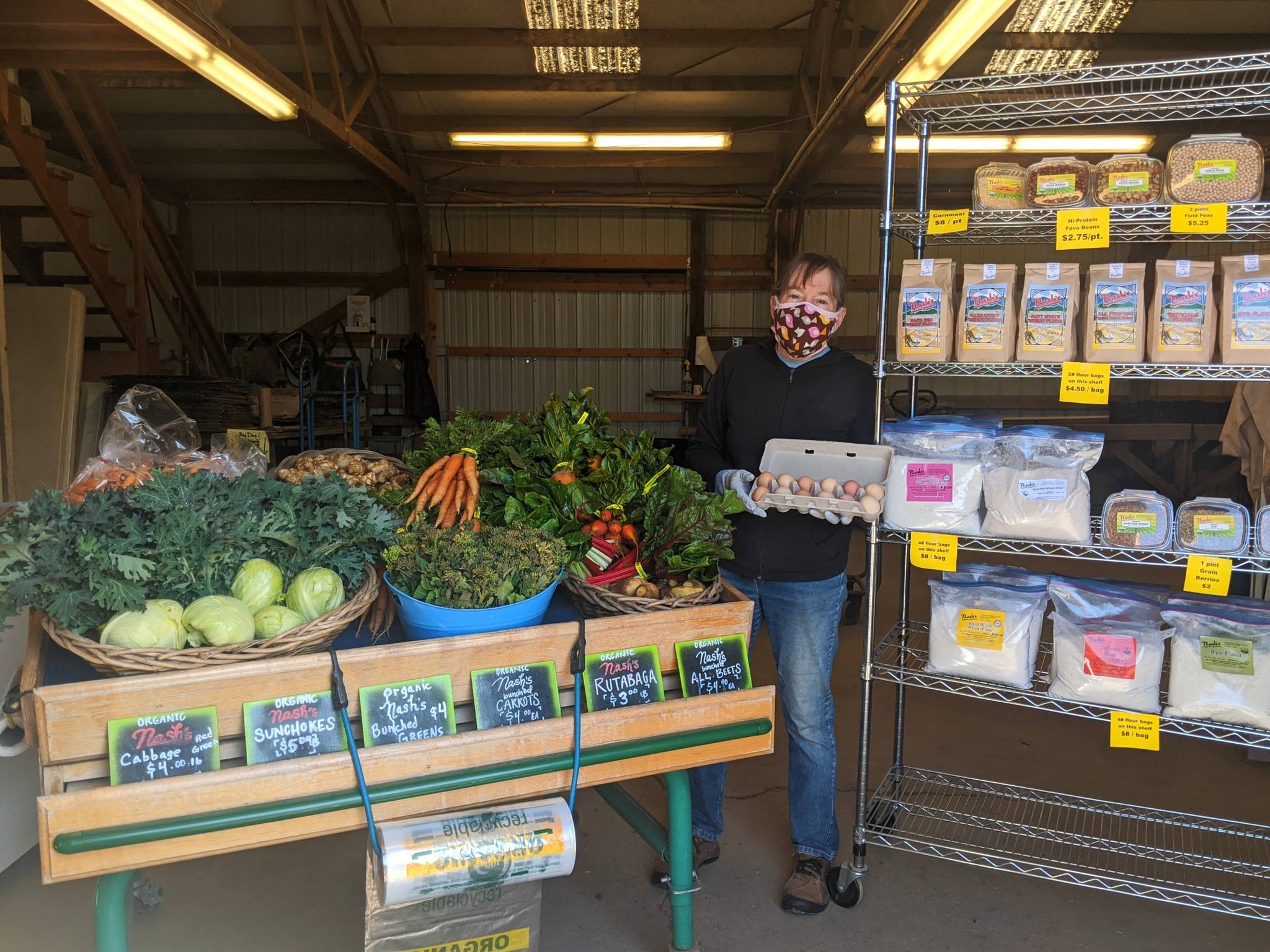 Nashs Farm Stand owner Patty McManus shows a low-contact way to buy local vegetables, camelina oil, flour, grain and eggs. Photo by Emma Jane Garcia