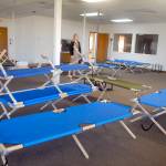 Jess Pankey, an environmental health specialist with Clallam County Heath and Human Services, looks over a room filled with cots last week at the Port of Port Angeles 1010 Building near William R. Fairchild International Airport as the building is converted to an isolation shelter for homeless individuals who might be infected with the novel coronavirus. Photo by Keith Thorpe/Olympic Peninsula News Group