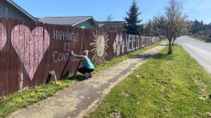 For about a week, Katie Smith worked with her children and some neighbors to draw an inspirational chalk mural along her subdivisions fence facing South Sequim Avenue. Photo courtesy of Isaac Peiffer