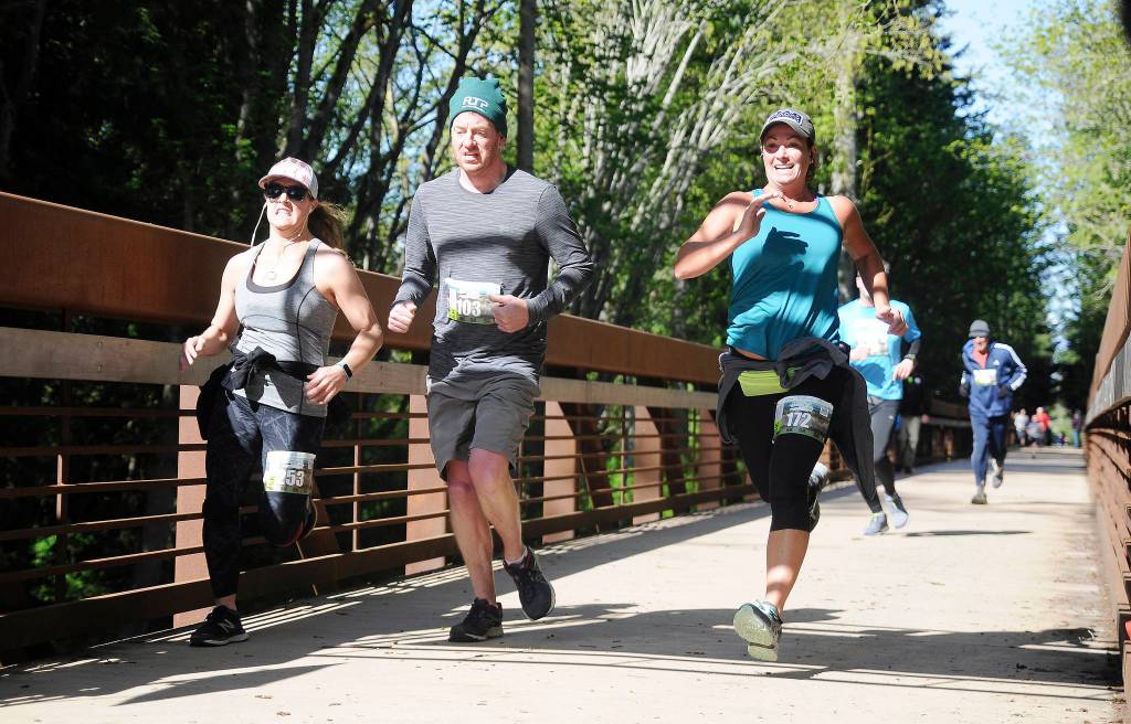 Runners reach the finish line at the Race the Peninsula series Railroad Bridge 5k/10k in Sequim in 2019. Sequim Gazette file photo by Michael Dashiell