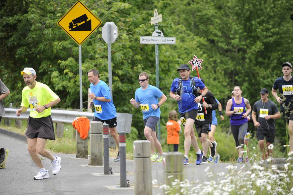 Runners in the 2017 North Olympic Discovery Marathon cross Whitefeather Way in Sequim. This years event, NODMs 18th, has been moved to virtual races with concerns of large group gathering exacerbating the novel coronavirus threat. Sequim Gazette file photo by Michael Dashiell