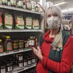 Sunny Farms Country Store employee Joan Ward displays one of her favorite local products: Sequim Bee Farms Wildflower Honey. Photo by Emma Jane Garcia