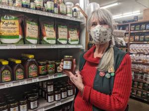 Sunny Farms Country Store employee Joan Ward displays one of her favorite local products: Sequim Bee Farms Wildflower Honey. Photo by Emma Jane Garcia