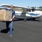 Kevin Chaney of Seattle, a member of the Boeing Employees Flying Association, offloads one of four boxes containing a total of 30,000 surgical masks destined for Olympic Medical Center after two aircraft arrived at William R. Fairchild International Airport in Port Angeles on Thursday, April 16, with supplies from the Washington State Hospital Association. Photo by Keith Thorpe/Olympic Peninsula News Group