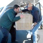 Bastian Hardtke, purchasing manager at Olympic Medical Center, left, takes a box from Boeing Employees Flying Association member Doug Weller of Seattle after two aircraft containing 30,000 surgical masks for the hospital arrived on Thursday, APril 16, at William R. Fairchild International Airport in Port Angeles. Photo by Keith Thorpe/Olympic Peninsula News Group