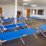 Jess Pankey, an environmental health specialist with Clallam County Heath and Human Services, looks over a room filled with cots on Thursday at the Port of Port Angeles 1010 Building near William R. Fairchild International Airport as the building is converted to an isolation shelter for homeless individuals who might be infected with the novel coronavirus. Photo by Keith Thorpe/Olympic Peninsula News Group