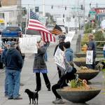 A group of about a dozen people against the states stay-at-home directives to combat spread of COVID-19 wave signs and flags at a gathering on Thursday, April 23, at Veterans Park in Port Angeles. Photo by Keith Thorpe/Olympic Peninsula News Group