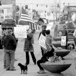 A group of about a dozen people against the states stay-at-home directives to combat spread of COVID-19 wave signs and flags at a gathering on Thursday, April 23, at Veterans Park in Port Angeles. Photo by Keith Thorpe/Olympic Peninsula News Group
